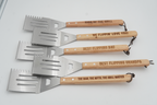 Set of five engraved spatulas with wooden handles on a white background